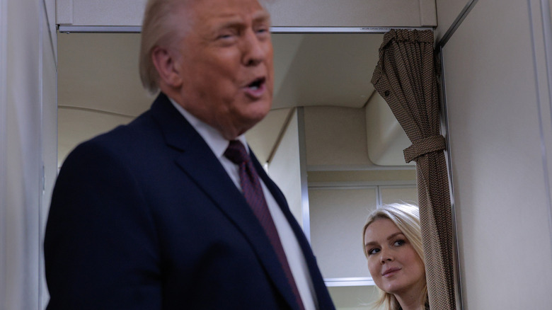 White House Press Secretary Karoline Leavitt listens to U.S. President Donald Trump speak to reporters on board Air Force One while flying in between Ireland and Washington while returning from the World Economic Forum on January 22, 2026.