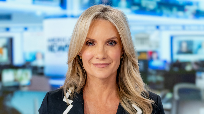 Dana Perino smiling in a black shirt and blazer at Fox News studio.