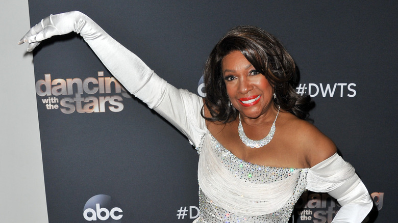 Mary Wilson posing in front of the Dancing with the Stars logo