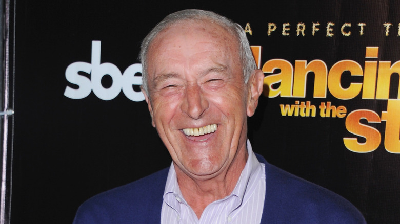 Len Goodman posing in front of a Dancing with the Stars background