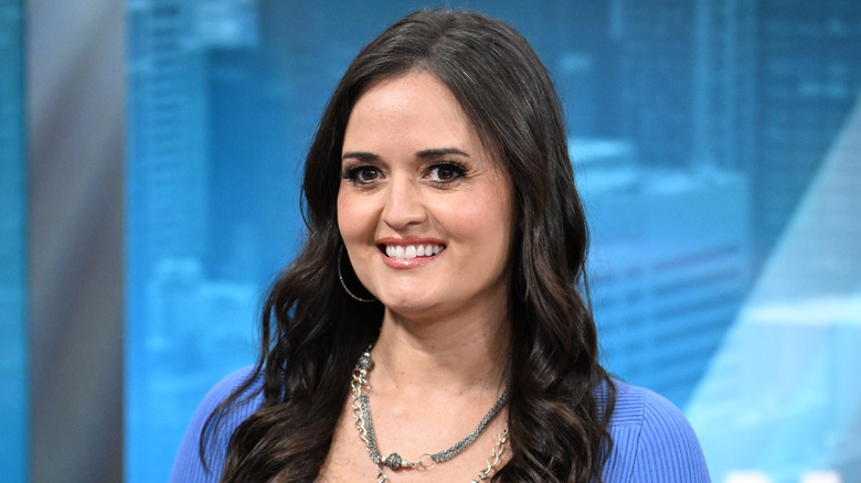 Danica McKellar smiling in a blue sweater