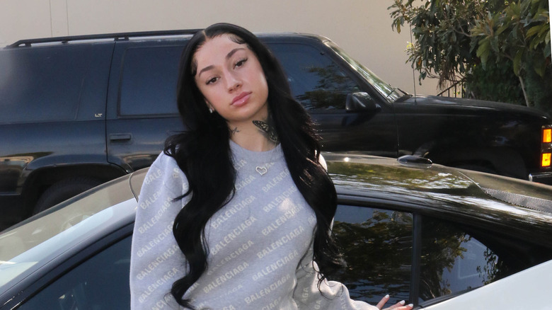 Bhad Bhabie standing in front of a car
