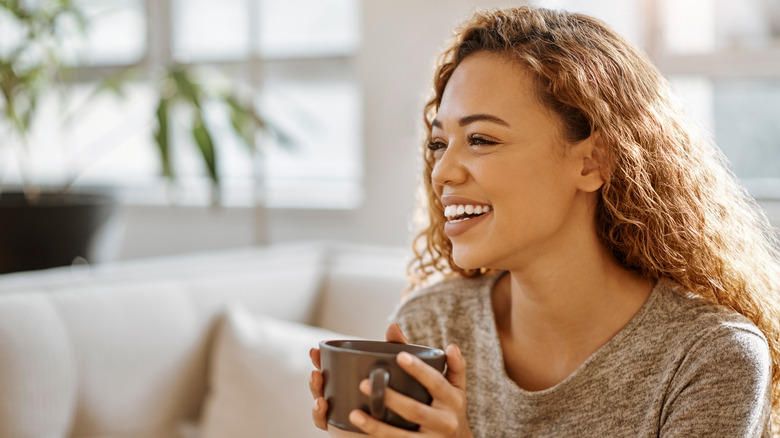 Woman with dark honey hair holding a mug