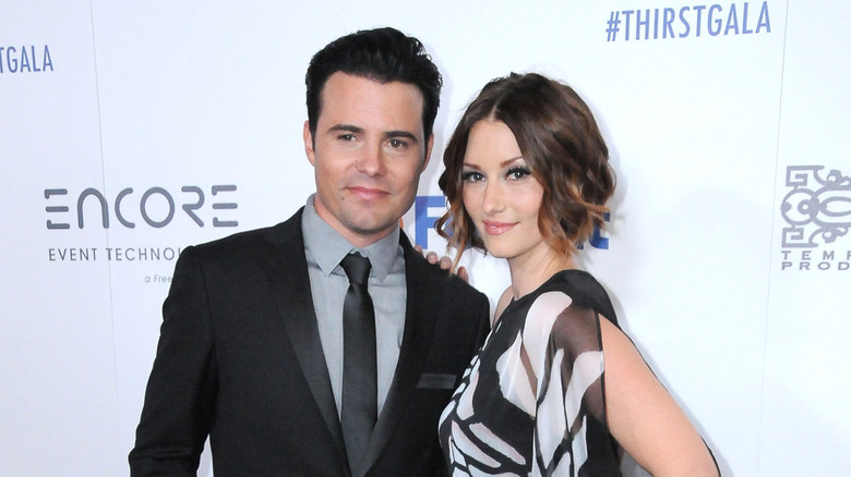 Chyler Leigh and Nathan West posing at an event