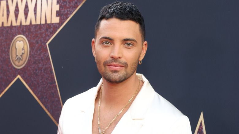 Benjamin Levy Aguilar wearing a gold necklace and earrings.