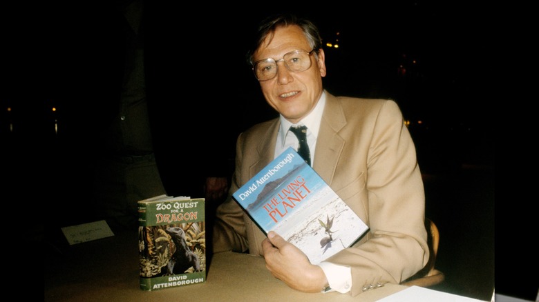 David Attenborough posing with books