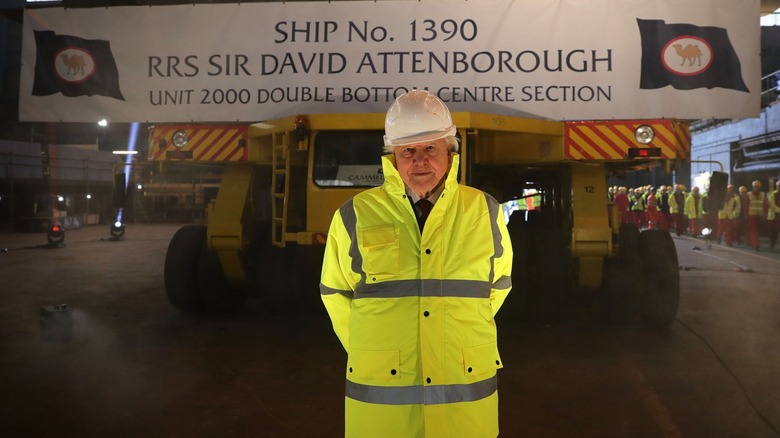 Sir David Attenborough standing in front of what will become the RRS David Attenborough ship