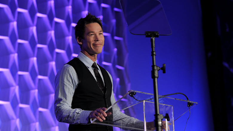 David Bromstad stands at a podium on stage