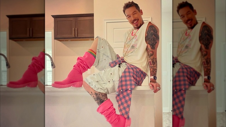 David Bromstad smiling and sitting on a kitchen island