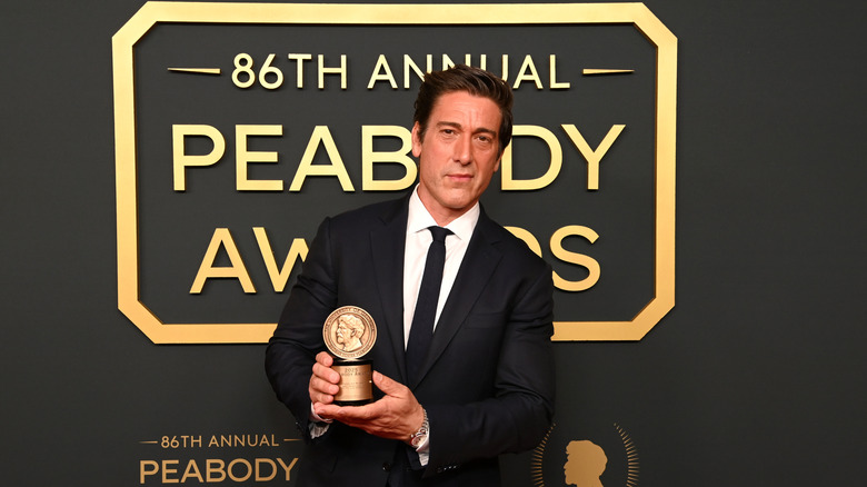 David Muir holding an award