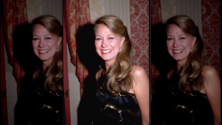 Jane Pauley smiling in a gold and black dress in 1981