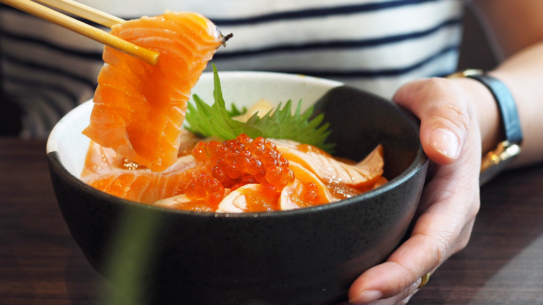 Woman eating salmon to boost her intake of omega-3s