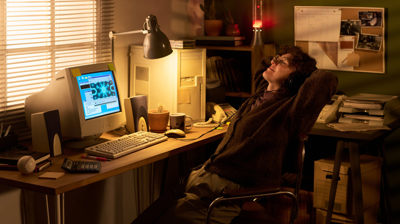 Woman with headphones leaning back and enjoying music on the PC