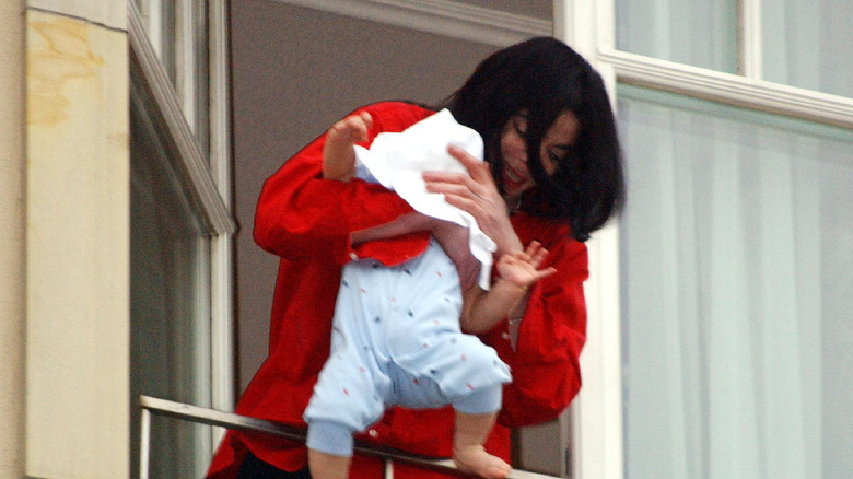 Michael Jackson dangling his baby off a balcony