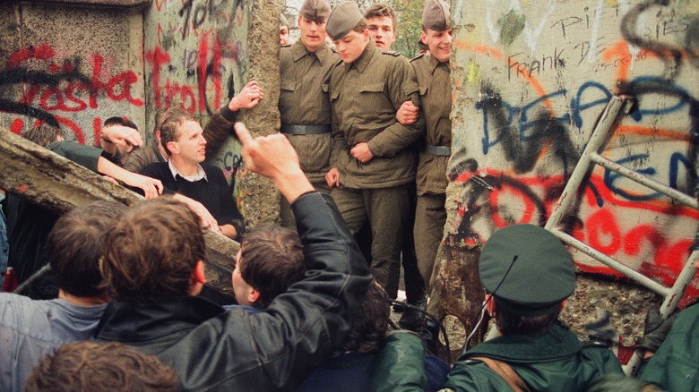 Soldiers allow Germans to tear down the Berlin Wall
