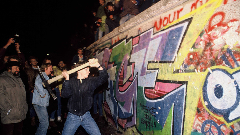 A man takes an axe to the Berlin Wall
