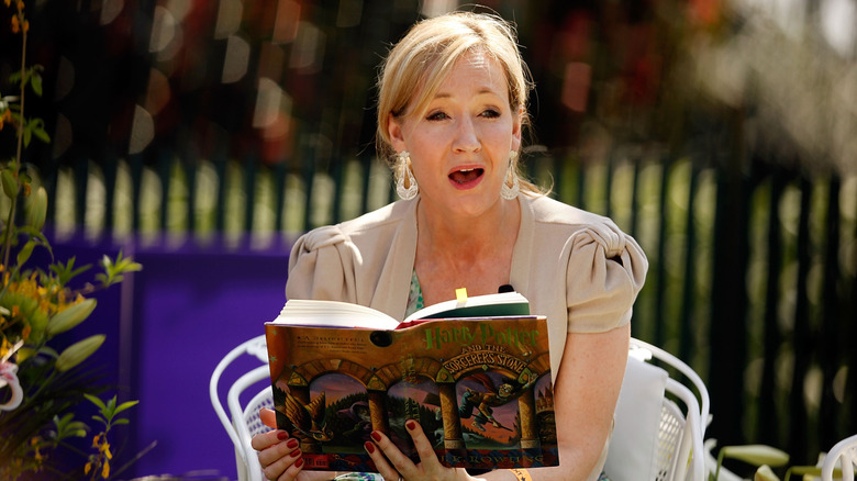J.K. Rowling holding a copy of Harry Potter and the Sorcerer's Stone