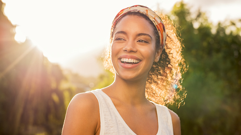 Woman smiling with bright sunlight behind her