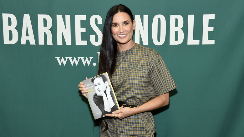 Demi Moore holding her memoir Inside Out