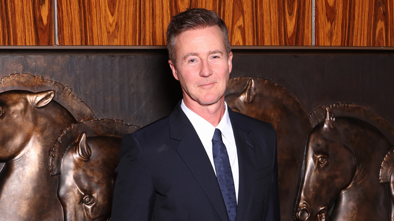Edward Norton in black formals and a navy tie