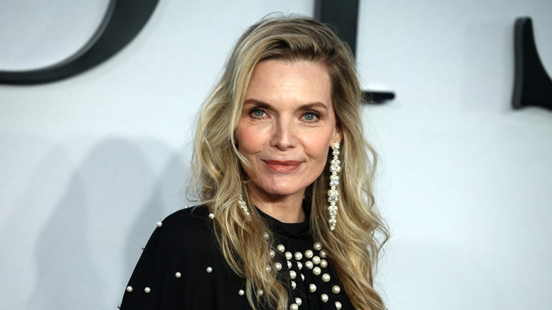Michelle Pfeiffer in a pearl-studded black outfit and long earrings