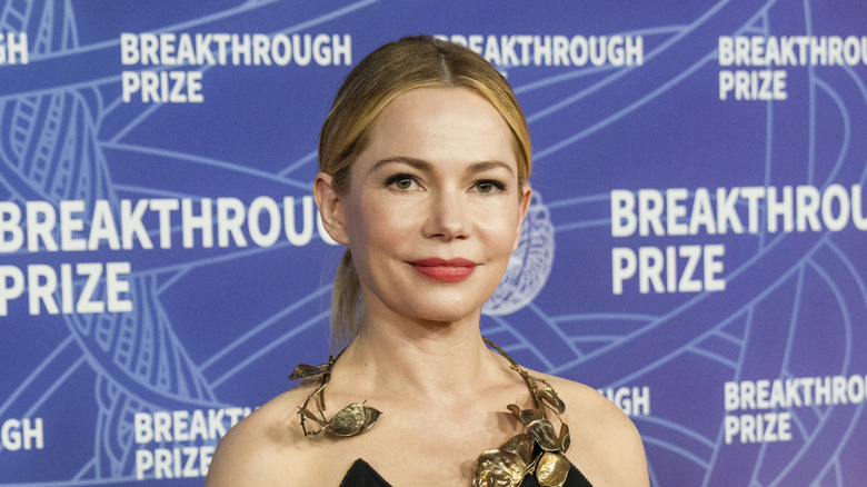 Michelle Williams in a black dress with an ornamental metal collar