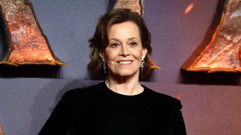 Sigourney Weaver in a round-neck black outfit and silver earrings