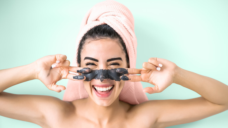 Woman applying a charcoal mask