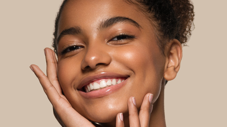 A woman with glowing skin smiling