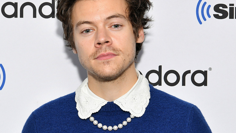 Harry Styles wearing collar and pearl necklace