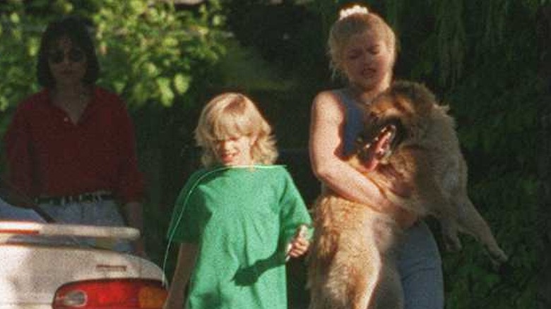Anna Nicole Smith carrying a dog and walking with Daniel Wayne Smith