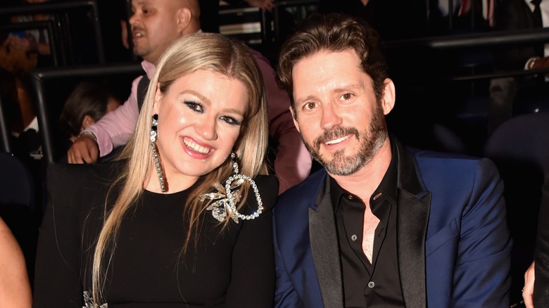 Kelly Clarkson and Brandon Blackstock sitting next to each other and smiling (2018)