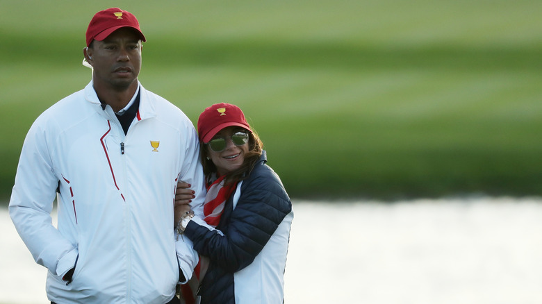 Erica Herman holding Tiger Woods' arm