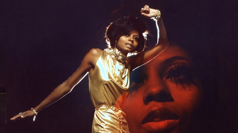 Diana Ross photographed by Harry Langdon in 1975, wearing a shiny dress with one arm up