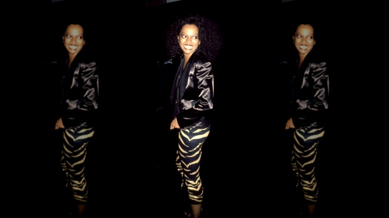 Diana Ross in tigerprint capri pants and a black blouse with a shimmering silk black jacket over it