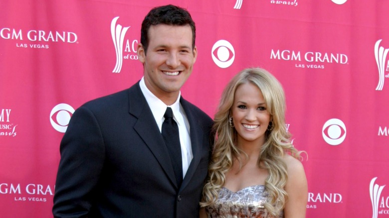 Tony Romo and Carrie Underwood pose for pictures.