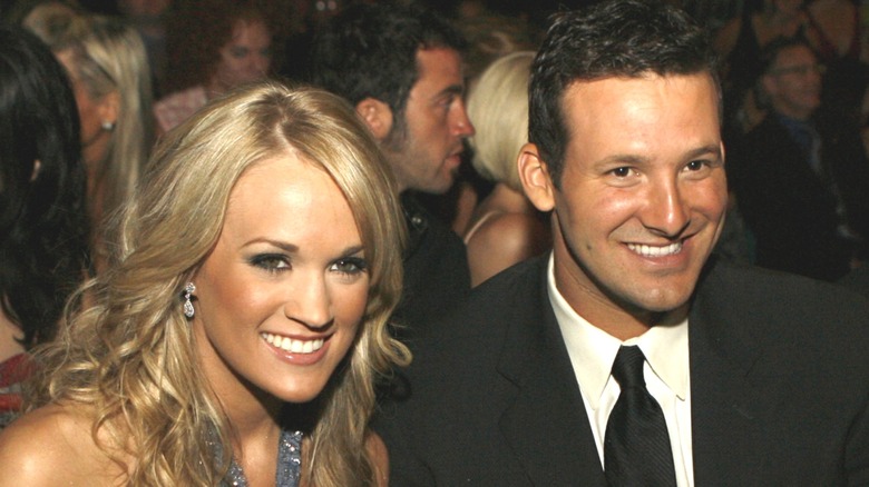 Carrie Underwood and Tony Romo sitting together at a public event.