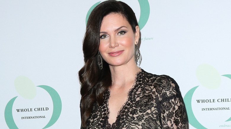 Karen Spencer smiling at the camera while posing at an event in a black lace dress