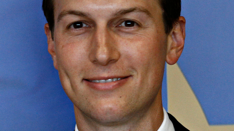 Jared Kushner with slight smile against a blue background