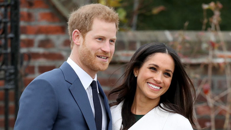 Prince Harry and Meghan Markle pose for the camera.