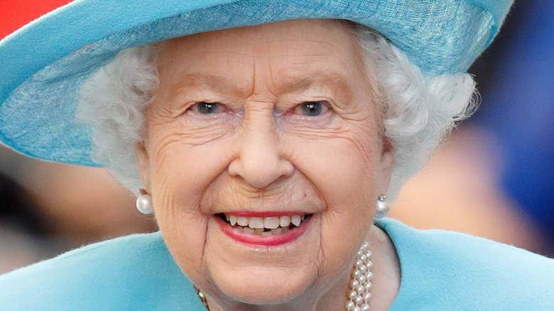 Queen Elizabeth smiling in an all-blue ensemble