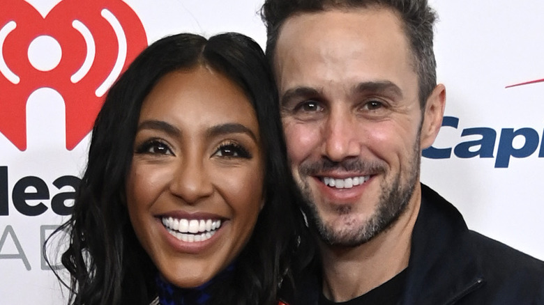 Tayshia Adams and Zac Clark smiling together at an event