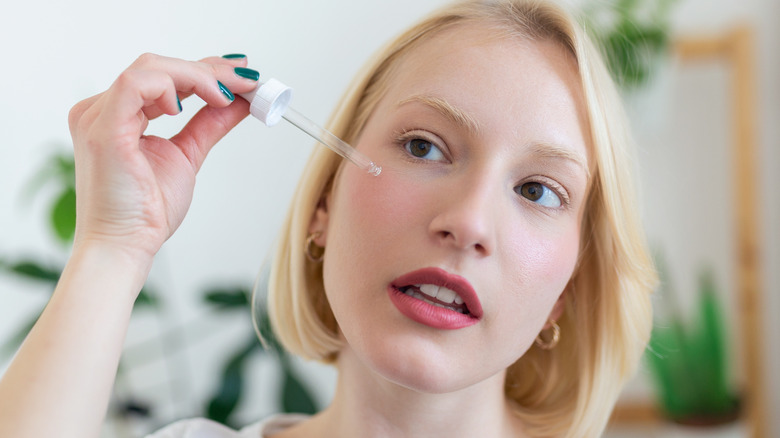 woman applying serum with dropper