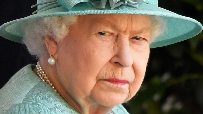 Queen Elizabeth II mean mugging the camera in a blue outfit