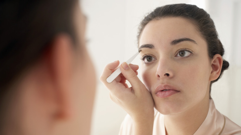 Woman filling in eyebrows