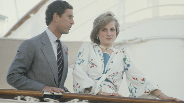A serious-looking King Charles III and Princess Diana standing next to each other