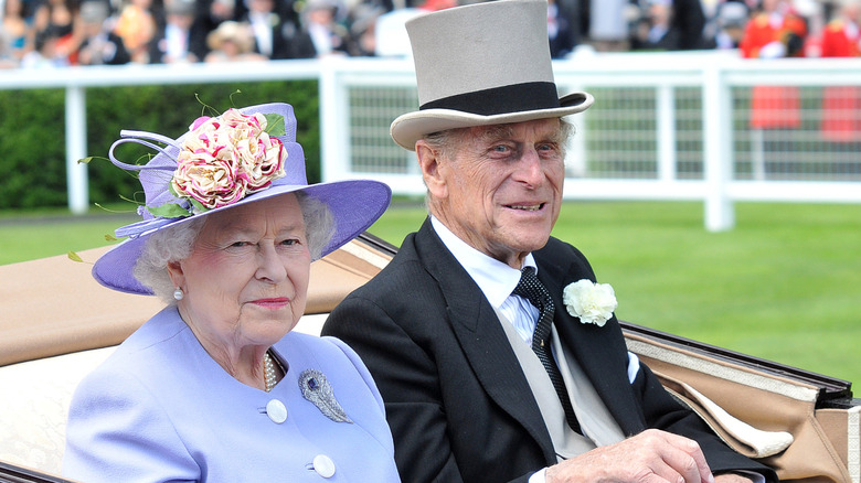 Queen Elizabeth II and Prince Philip riding together in a carriage