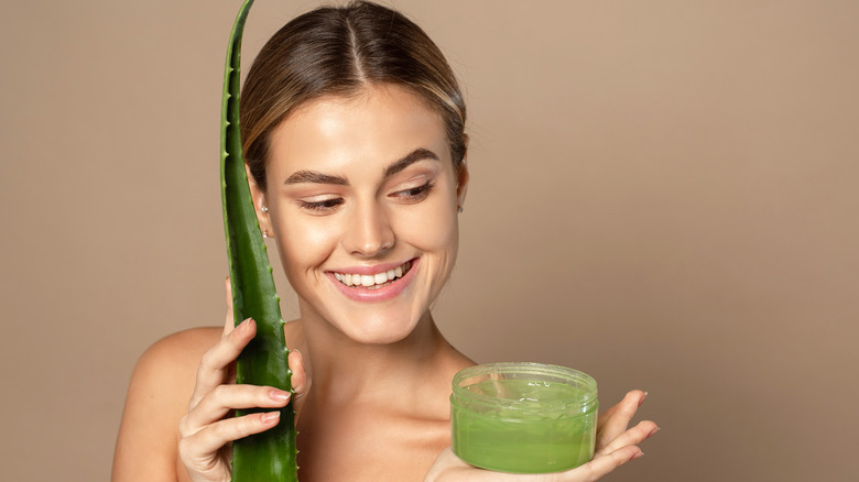 Woman with green aloe vera plant gel