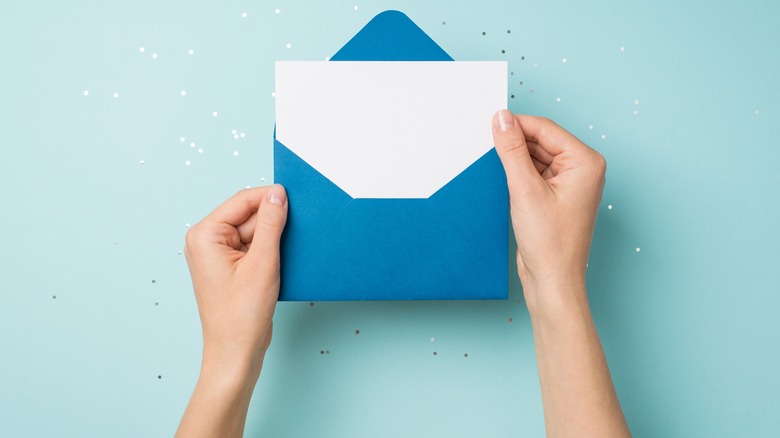 a woman's hands open an envelope