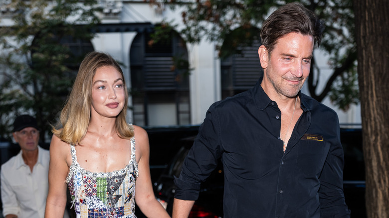 Gigi Hadid and Bradley Cooper walking while holding hands